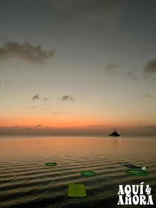 a sunset over the water with a boat in the distance at Aqui Ahora at Villa Verde in San Andrés +21 photos