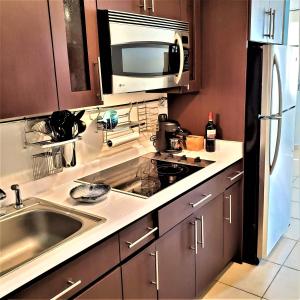 a kitchen with a sink and a microwave at KASA Seahorse of the Sea - Studio for 2 BEACH BLOCK in San Juan +24 photos