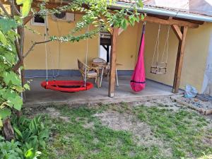 a porch with a swing and a table and a chair at Dora in Sremski Karlovci