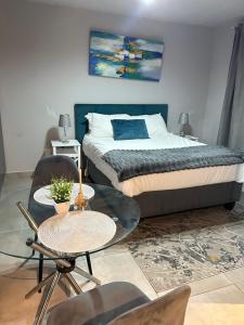 een slaapkamer met een bed en een tafel en stoelen bij Circa Lynnwood in Pretoria