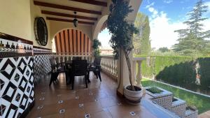 porche con mesa y sillas en el balcón en Casa Monte Verde con piscina a 10 min de Granada, en Cájar