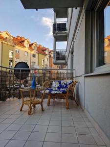 a patio with a table and chairs on a balcony at Apartament centrum Gdynia Dąbrowa in Gdynia