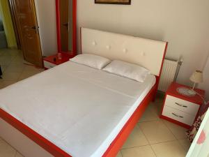 费里4 Bed Villa - Sleeps 9 - Pets - Garden - Parking的一间卧室配有一张大白色床和红色床头柜