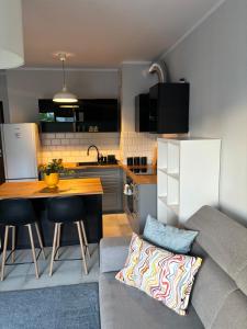 Una pequeña cocina con una mesa y un sofá. en Altoria Sunset Gdynia, en Gdynia