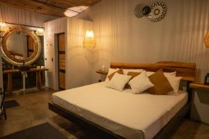 um quarto com uma cama com lençóis brancos e um espelho em Jungla EcoLuxury Resort em Villeta