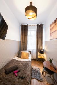 Dormitorio pequeño con cama y mesa en ClickTheFlat Wolska Apart Rooms, en Varsovia