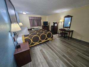 a hotel room with a bed and a desk at Super 8 by Wyndham Clinton in Clinton