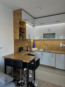 een keuken met witte kasten en een houten aanrecht bij Ana apartman in Jagodina