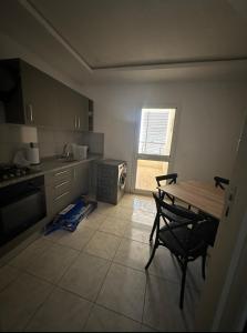 a kitchen with a table and a table and chairs at Bel appartement in Zarzis