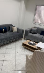 a living room with two couches and a coffee table at Bel appartement in Zarzis