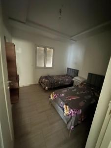 a room with two beds in a room at Bel appartement in Zarzis