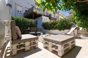 eine Terrasse mit 2 Bänken, einem Tisch und Stühlen in der Unterkunft Casa da Travessa in Lissabon