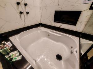 a white bath tub in a bathroom with marble walls at Único Motel Faria Lima in Sao Paulo