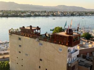 a balcony on top of a building next to a body of water at Arabesque Dome Roof Gardens in Luxor