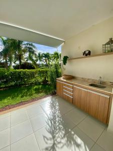 a kitchen with a sink and a view of a garden at Refúgio na Praia do Forte in Praia do Forte