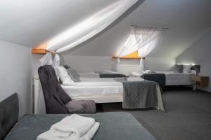 pokój hotelowy z dwoma łóżkami i krzesłem w obiekcie Perla w mieście Augustów
