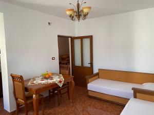 um quarto com uma cama e uma mesa e uma cama e uma mesa e cadeiras em Stiven’s Apartment em Berat