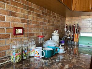 a kitchen counter with jars and cups on it at Stiven’s Apartment in Berat