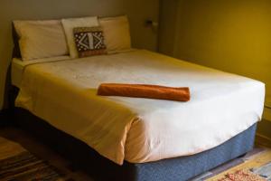 a large bed with a pillow on top of it at Hyenas Howl Cabins in Muchenje