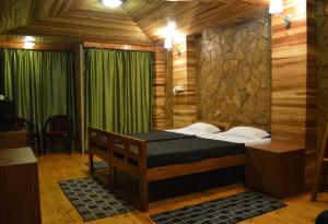 a bedroom with a bed in a room with green curtains at Quinton Enclave in Shillong