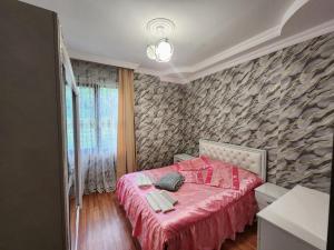 a bedroom with a red bed and a stone wall at Villa in Chakvi in Chakvi