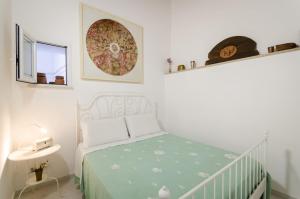 ein Schlafzimmer mit einem Kinderbett mit grüner Tagesdecke in der Unterkunft Il Giardino di Lucia in Syrakus