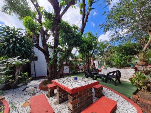 un patio con mesa, sillas y un árbol en HI Hostel Chapada, en Lençóis