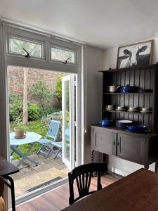 Charming, Renovated Residence in Willesden Green في لندن: غرفة معيشة مع طاولة ونافذة وطاولة