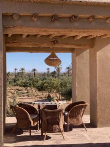 a patio with a table and chairs and a chandelier at Dar faracha in Ouarzazate