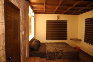 a bedroom with a bed and a window at Mistil Garden Resort in Kozhikode