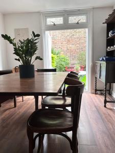 a dining room table with chairs and a potted plant at Charming, Renovated Residence in Willesden Green in London