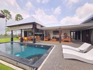 eine Villa mit einem Pool und einem Haus in der Unterkunft Belvilla 93799 Kasuari Villa Three Bedroom At Taro Village Ubud in Penginyahan