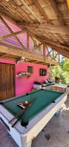 a room with a pool table and a pink wall at Villa Rosa in Punta Rucia