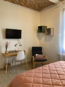 Schlafzimmer mit einem Bett, einem Schreibtisch und einem TV in der Unterkunft Ospedale Baggiovara - Modena appartamento Giardini 