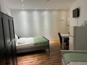 a bedroom with a bed and a desk and a table at Pension Baku in Fürth