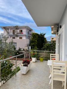 einen Balkon mit einem Tisch und Bänken sowie ein Gebäude in der Unterkunft Xhonis Apartments in Ksamil