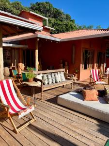 a deck with two beds and chairs on a house at Casa Tuco - Cumuruxatiba in Cumuruxatiba