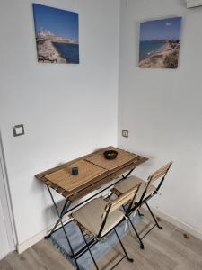une table et des chaises devant un mur avec deux photos dans l'établissement Apartamento céntrico y sencillo en El Puerto, à El Puerto de Santa María