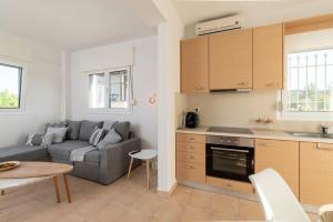 a kitchen and living room with a couch and a table at Aethra Terrace - Sea View Retreat in Hanioti