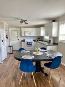 una cucina con tavolo nero e sedie blu di Little Pet Friendly House a Greeneville