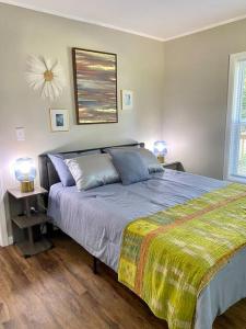 a bedroom with a bed with a blanket and two lamps at Little Pet Friendly House in Greeneville