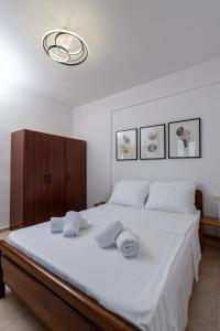 1 dormitorio con 1 cama blanca grande y toallas. en Aethra Nature's Sanctuary en Chanioti