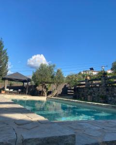 una piscina de agua azul en un patio en Hacienda Tresoles, en Ubrique