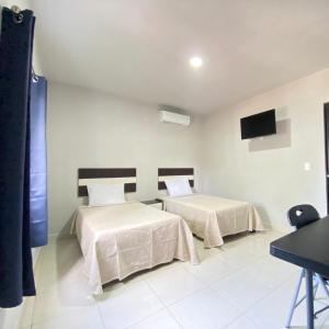 a bedroom with two beds and a flat screen tv at HOTEL TAMPICO EXPRESS MORALILLO in Tampico