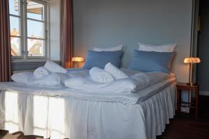 Una cama grande con mantas blancas y almohadas. en Hotel Kysten, en Hasle