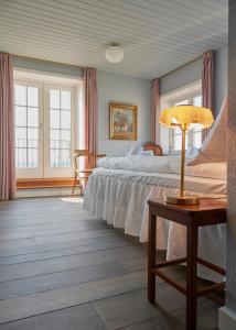 a bedroom with two beds and a table with a lamp at Hotel Kysten in Hasle