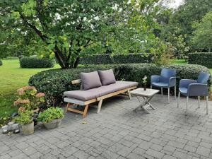 un divano e 2 sedie seduti su un patio di B&B De Levensboom a Tessenderlo