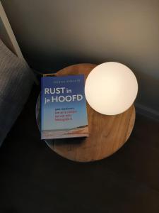 un libro seduto su un tavolo accanto a una lampada di B&B De Levensboom a Tessenderlo