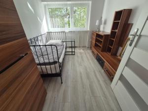 a hallway with a chair and a wooden floor at Apartament Brzechwy in Poznań