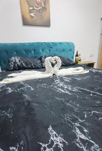 una cama con un edredón blanco y negro en Apartman VRH, en Vrnjačka Banja